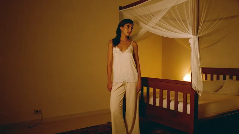 The shade seeker, the same camisole and trousers by the candle-lit canopy bed at night