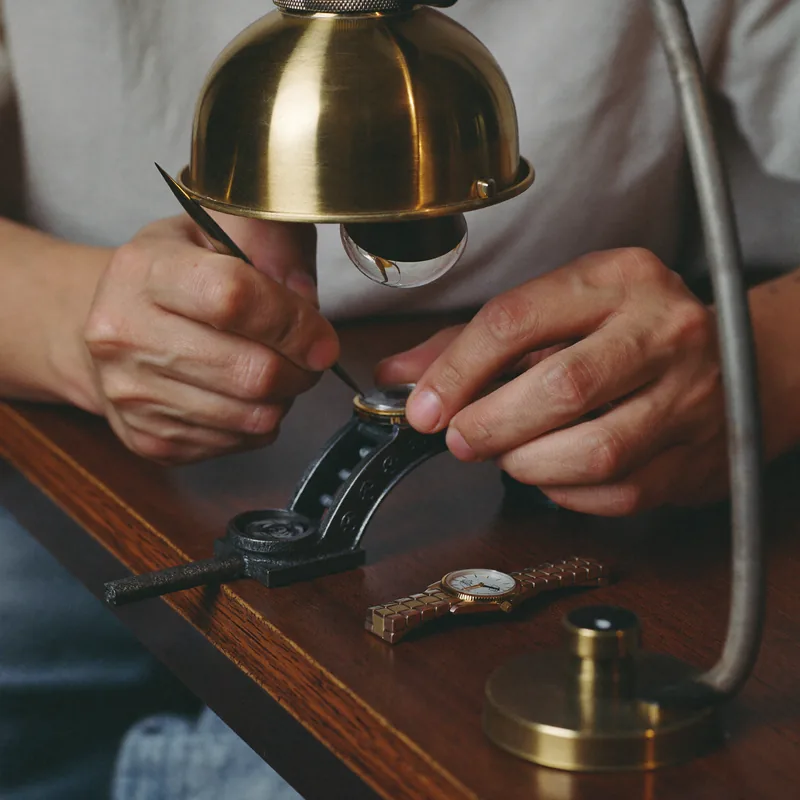 Bevelling: hands bevelling a bridge with a file under a loupe