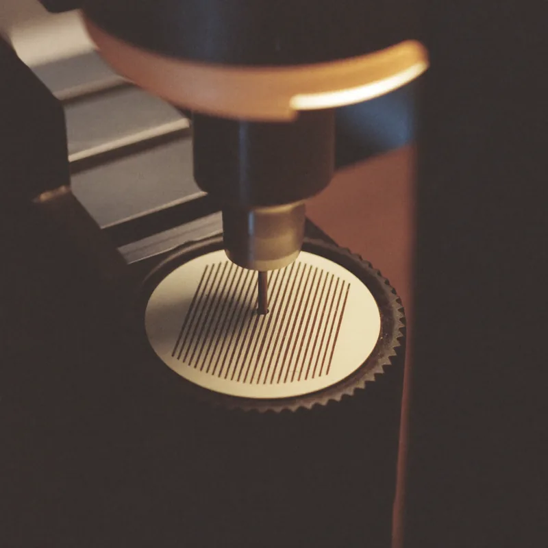 Côtes de Genève: a rotating tool cutting Côtes de Genève stripes into a brass disc